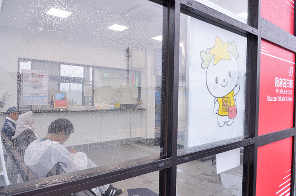 降りしきる雨の中、駅待合室で過ごす遠方来訪者ら=陸前高田