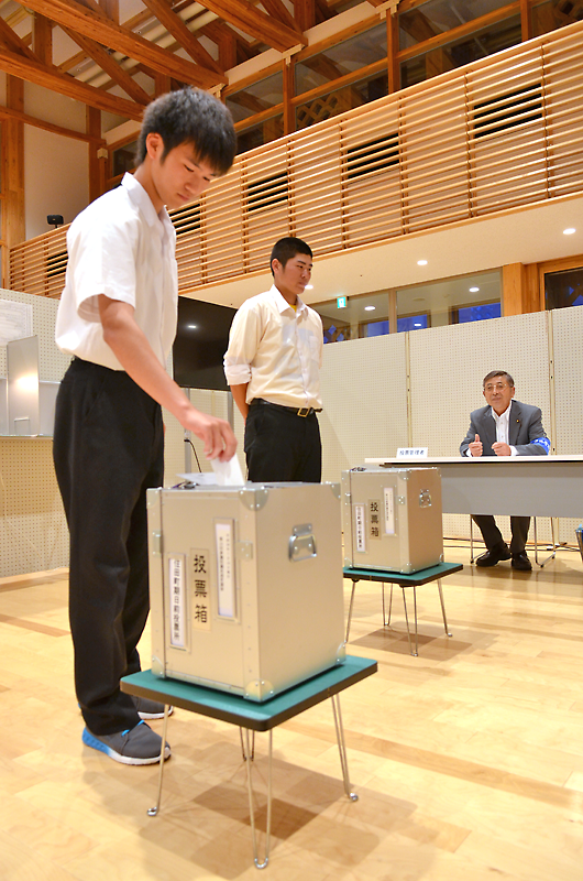 期日前の手続きをとった住田高校生２人は投票箱に＝同