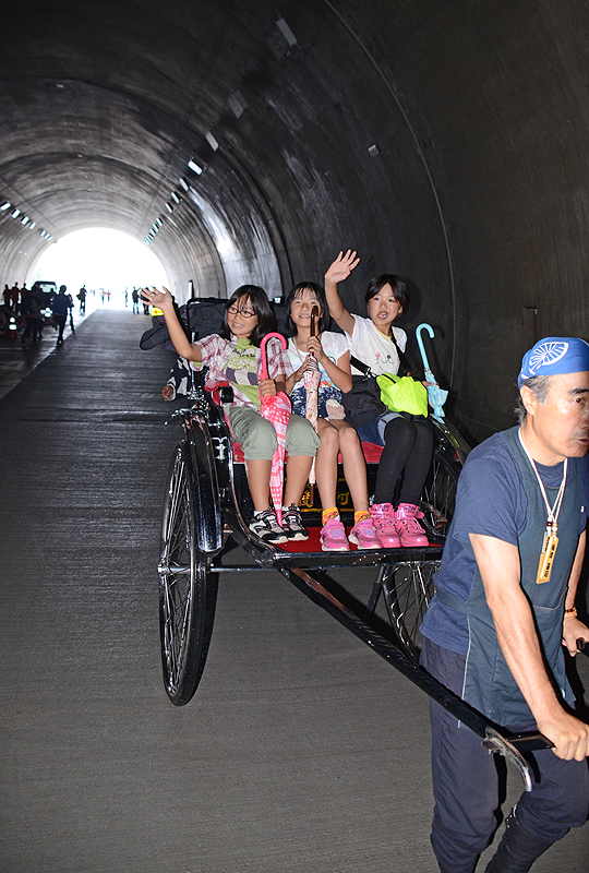 人力車に試乗し、手を振る子どもたち=同