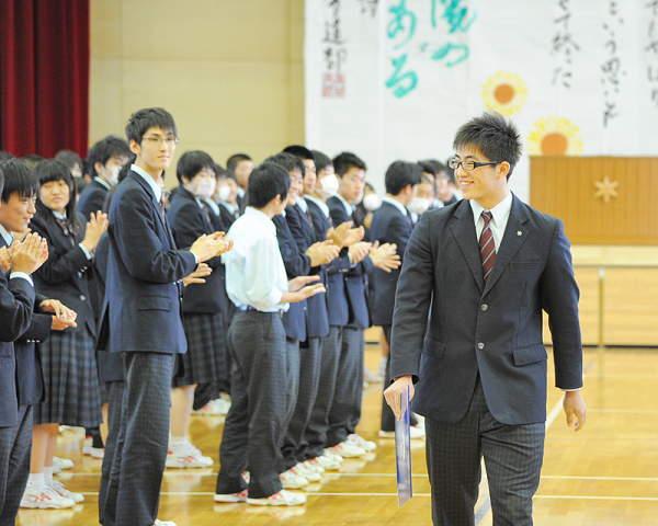 凱旋し、生徒たちに祝福されて笑顔をみせる長沼選手=県立高田高校