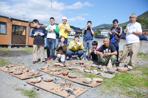 それぞれ制作した陶芸品を手にする利用者ら=同