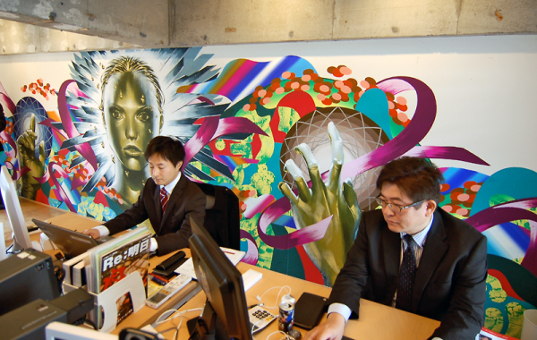 富士ソフトでは社員２人が常駐。職場の壁には大高美術部員の案をもとにした絵が描かれる＝同