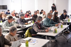 熱心な表情で講演に耳を傾ける参加者＝同