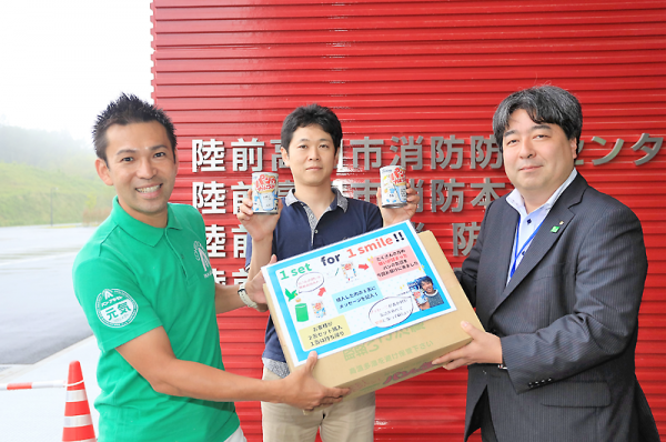 秋元さん㊧と大西さん㊥が訪れ、缶詰パンを贈呈した=高田町